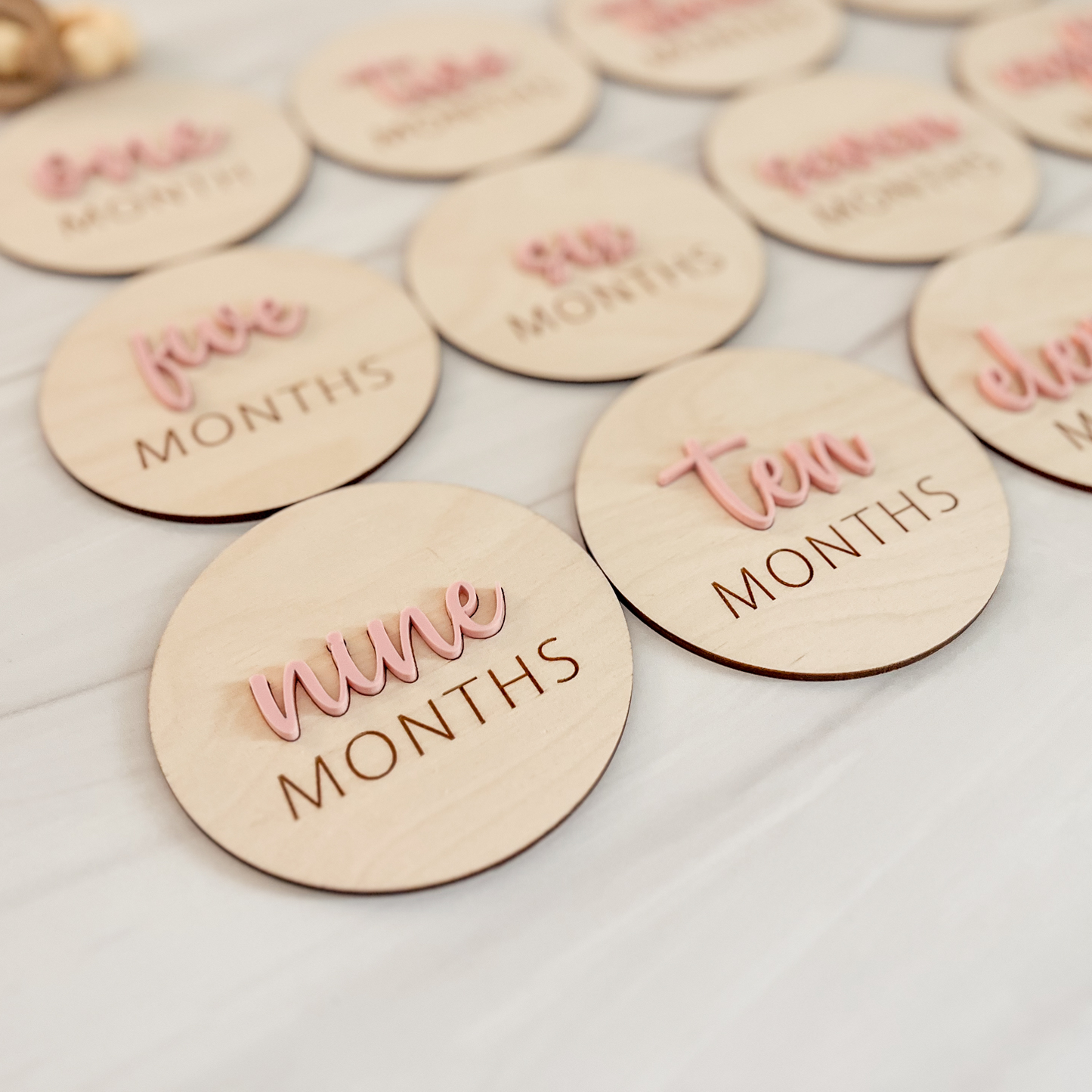 Wooden circular markers with text indicating months on a light background