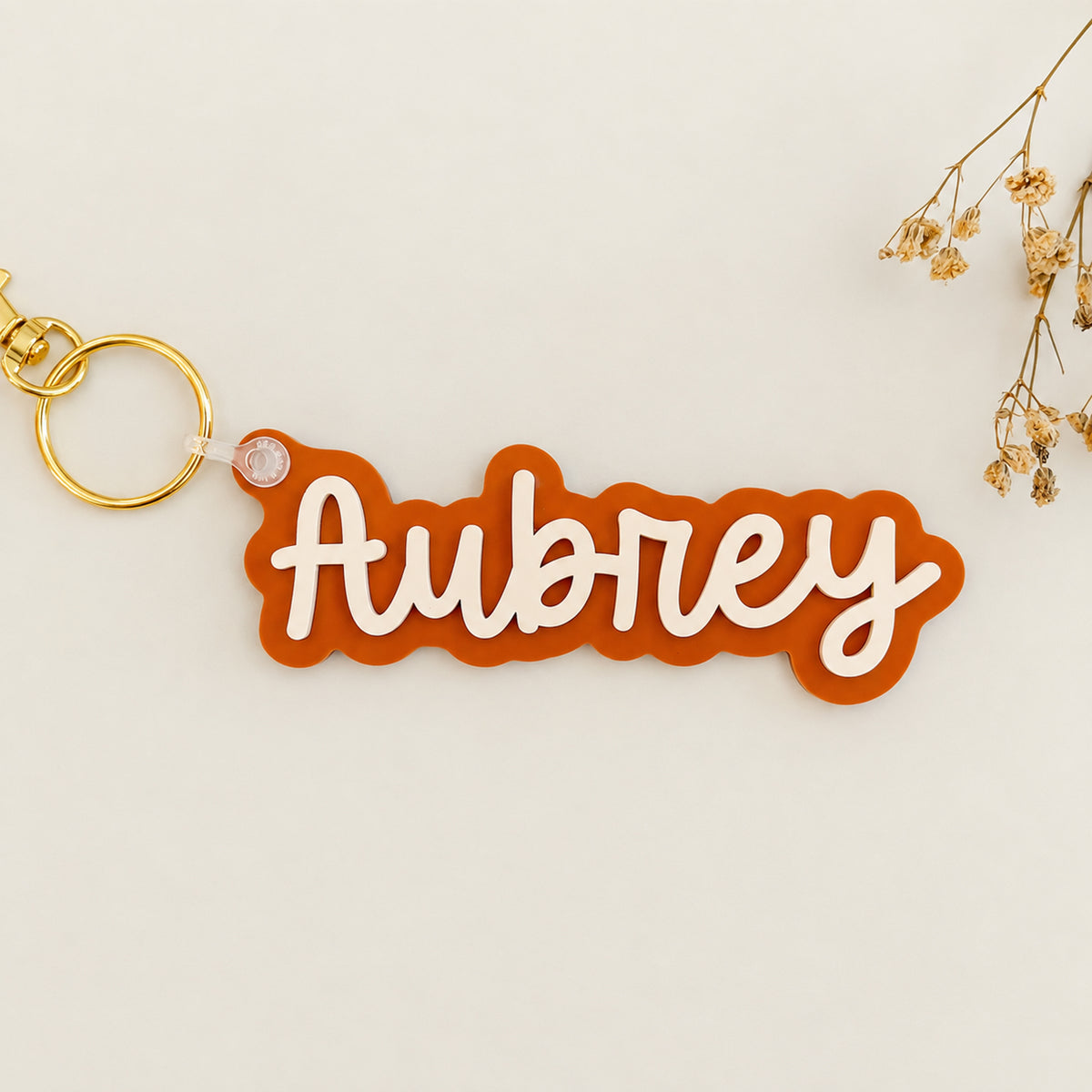 Solid color acrylic name keychain spelling Aubrey with gold keyring.
