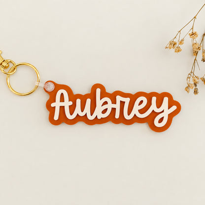 Solid color acrylic name keychain spelling Aubrey with gold keyring.
