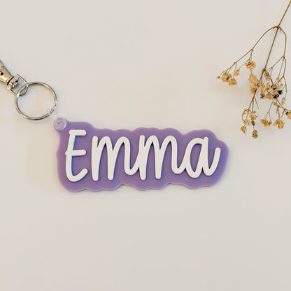 Solid color acrylic name keychain spelling Emma with silver keyring.
