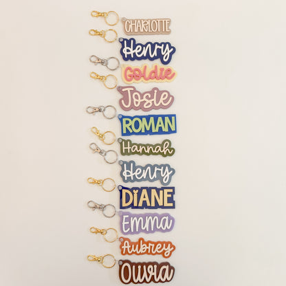 Group of personalized solid color acrylic name keychains in assorted colors.