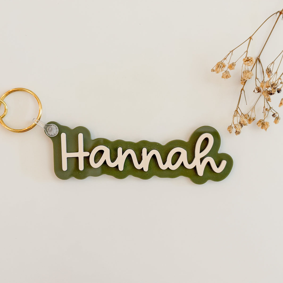 Solid color acrylic name keychain spelling Hannah with gold keyring.