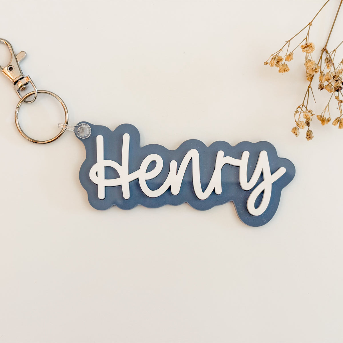 Solid slate blue color acrylic name keychain spelling Aubrey with silver keyring.