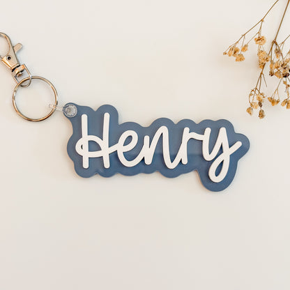 Solid slate blue color acrylic name keychain spelling Aubrey with silver keyring.