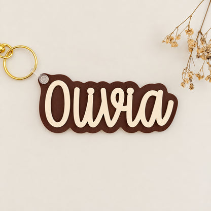 Solid color acrylic name keychain spelling Olivia with gold keyring.