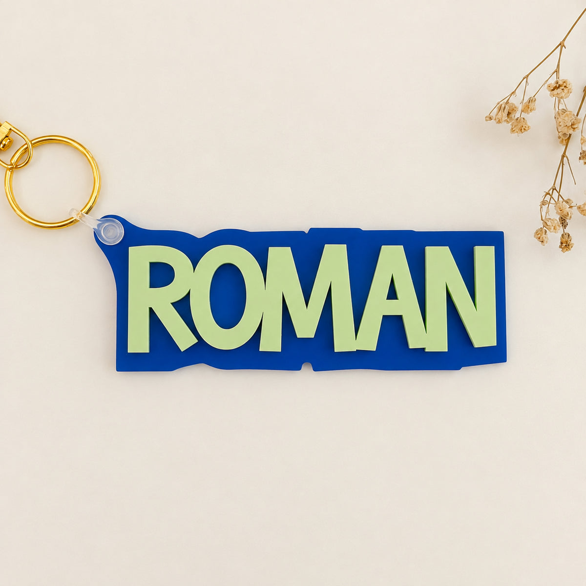 Solid color acrylic name keychain spelling Roman with gold keyring.